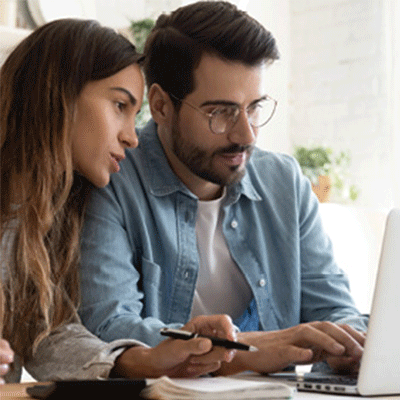 A man and woman looking thoughtfully at a computer screen